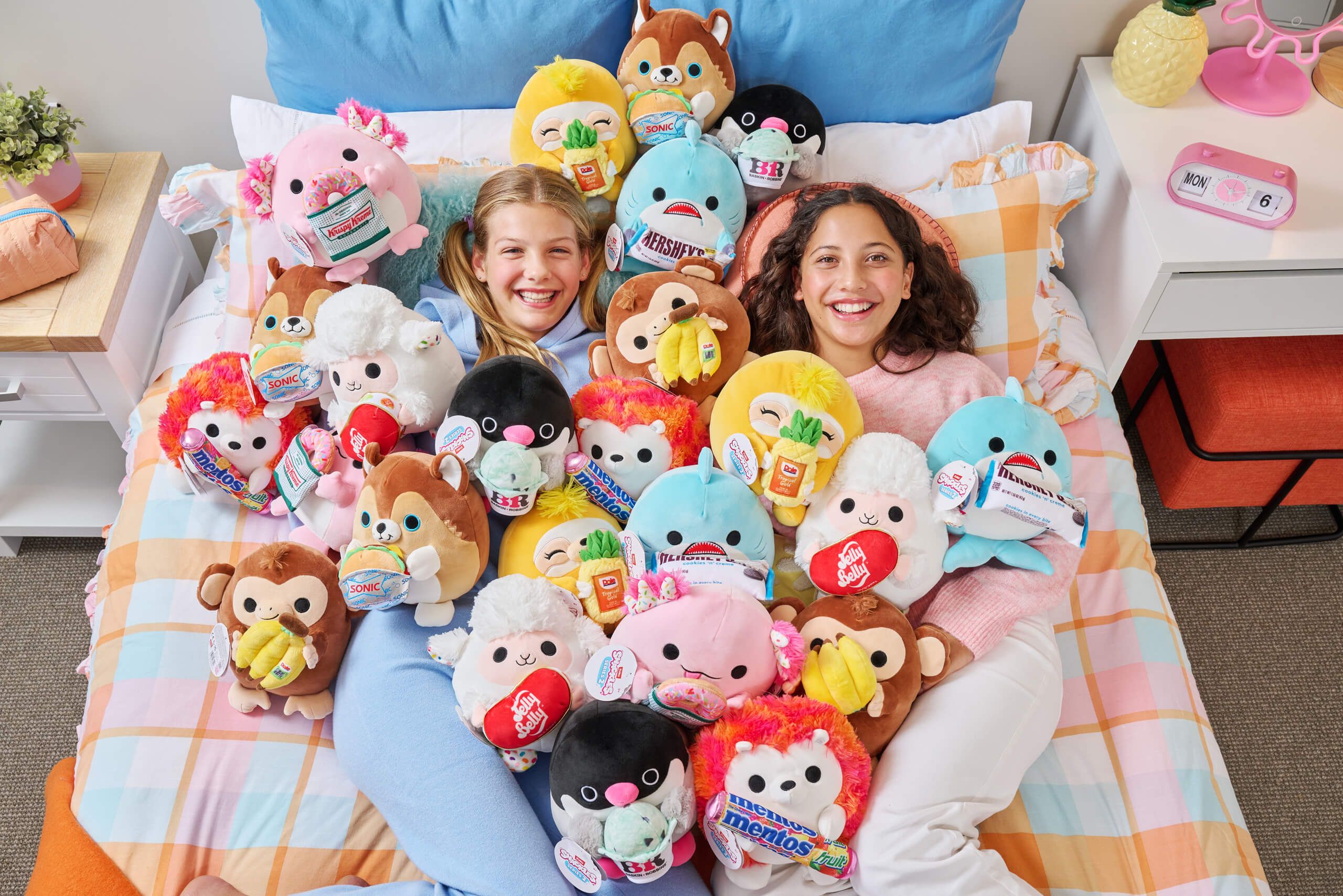 Girl laying on pile of snackles plushies | ZURU Toys